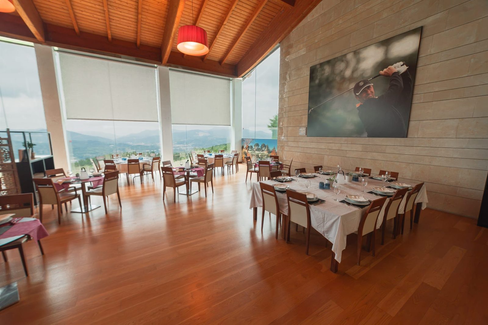 Comedor con mesas vestidas y vistas al monte a través de los ventanales